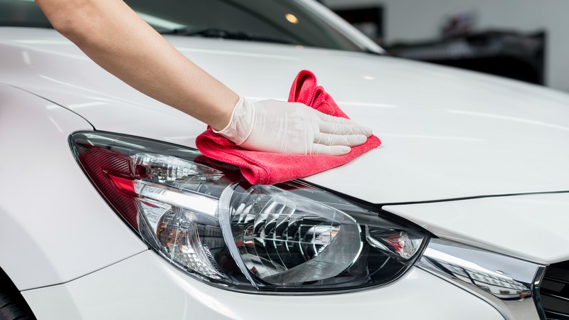 Hand with a wipe the car polishing. White car
